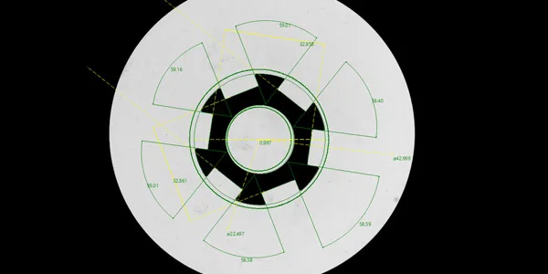 Vertical Visigauge camera view: part silhouette with the measurement overlays — a gear-type pressed part on the stage