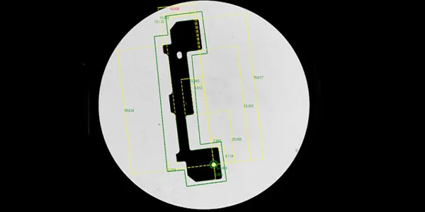 Vertical Visigauge camera view: part silhouette with the measurement overlays — a bracket-type stamping